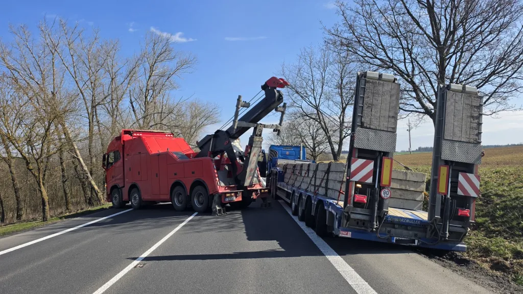 Nákladní kolos uvízl na okraji vozovky. Těžká technika bojovala s 60tunovou soupravou