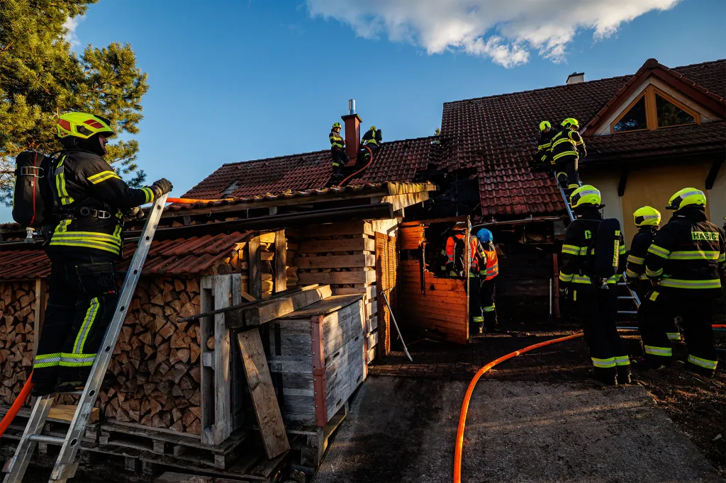 Plameny ničily garáž a hrozily i domu. Obyvatelé se snažili hasit sami, dva skončili u záchranářů